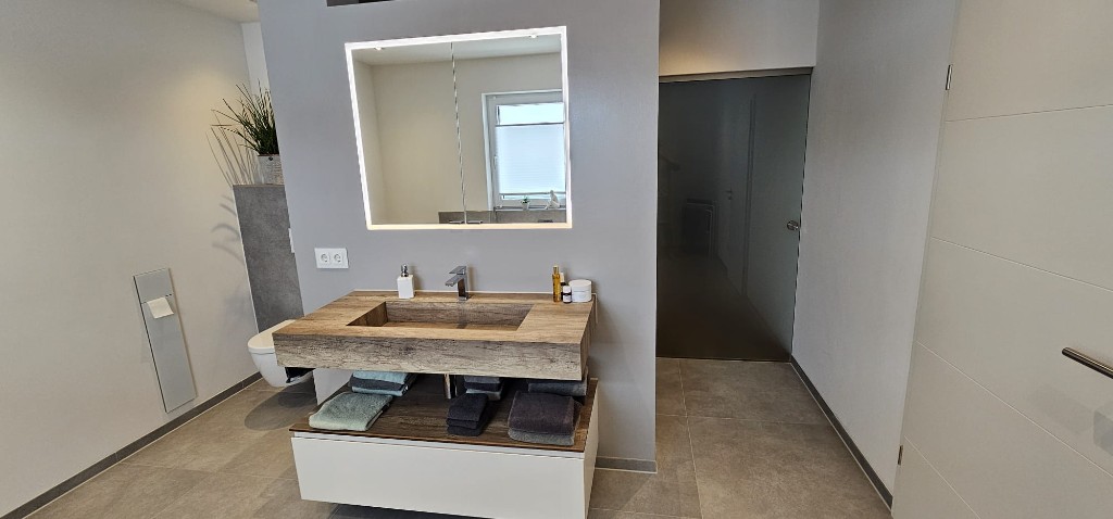 Waschtisch mit Holzplatte und beleuchtetem Spiegelschrank